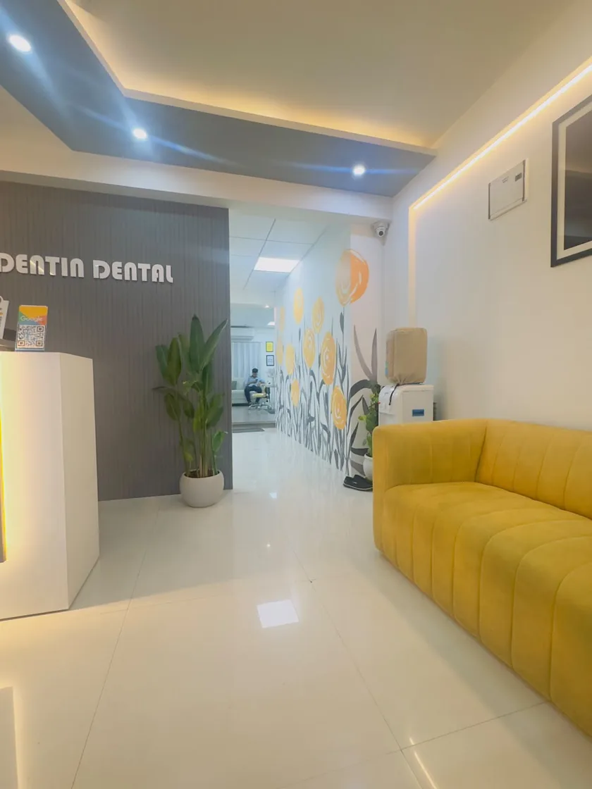 Waiting area with yellow sofa at DENTIN Multispeciality Dental Clinic & Implant Center, HSR Layout Bengaluru