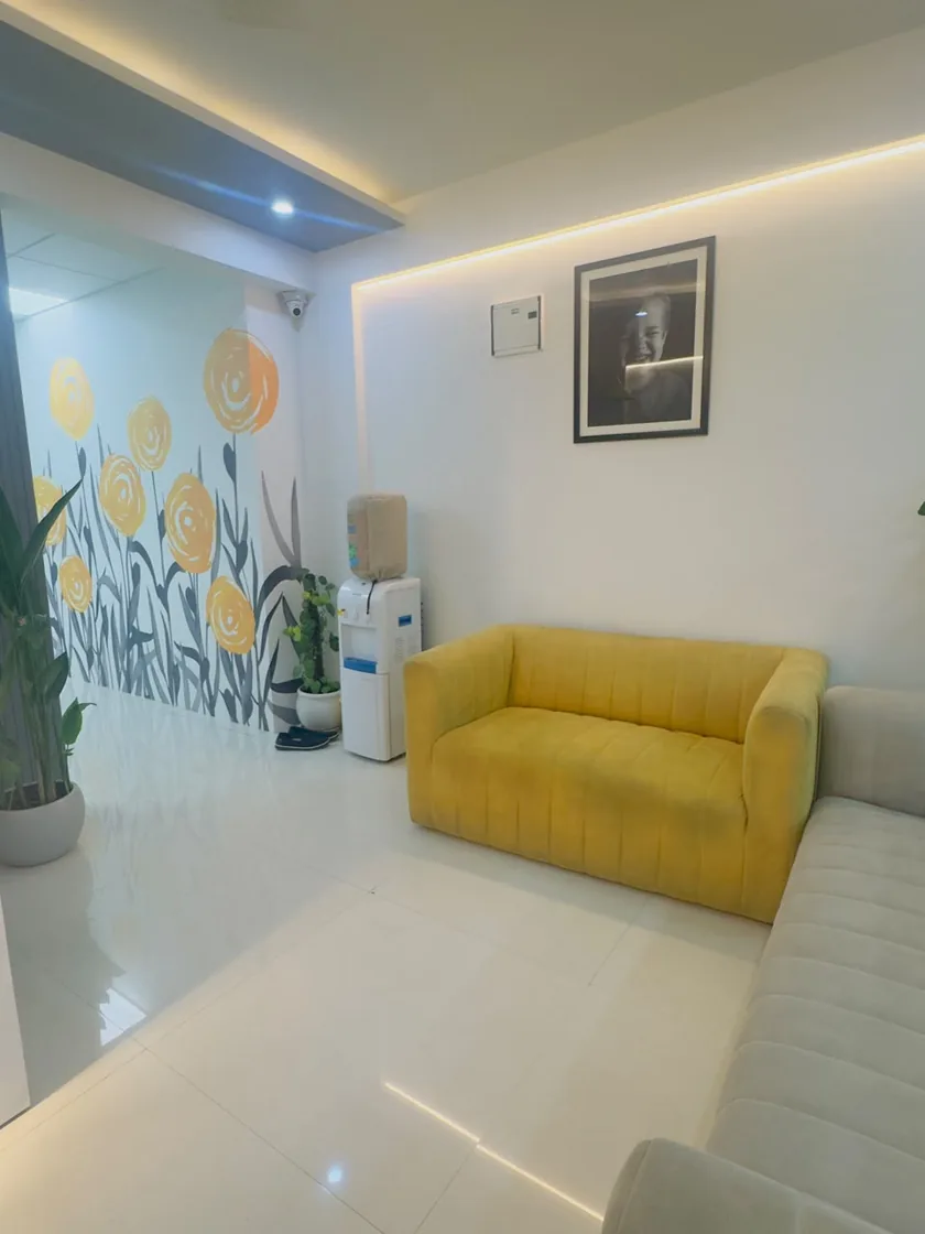 Waiting lounge with yellow sofa at DENTIN Multispeciality Dental Clinic & Implant Center, HSR Layout Bengaluru